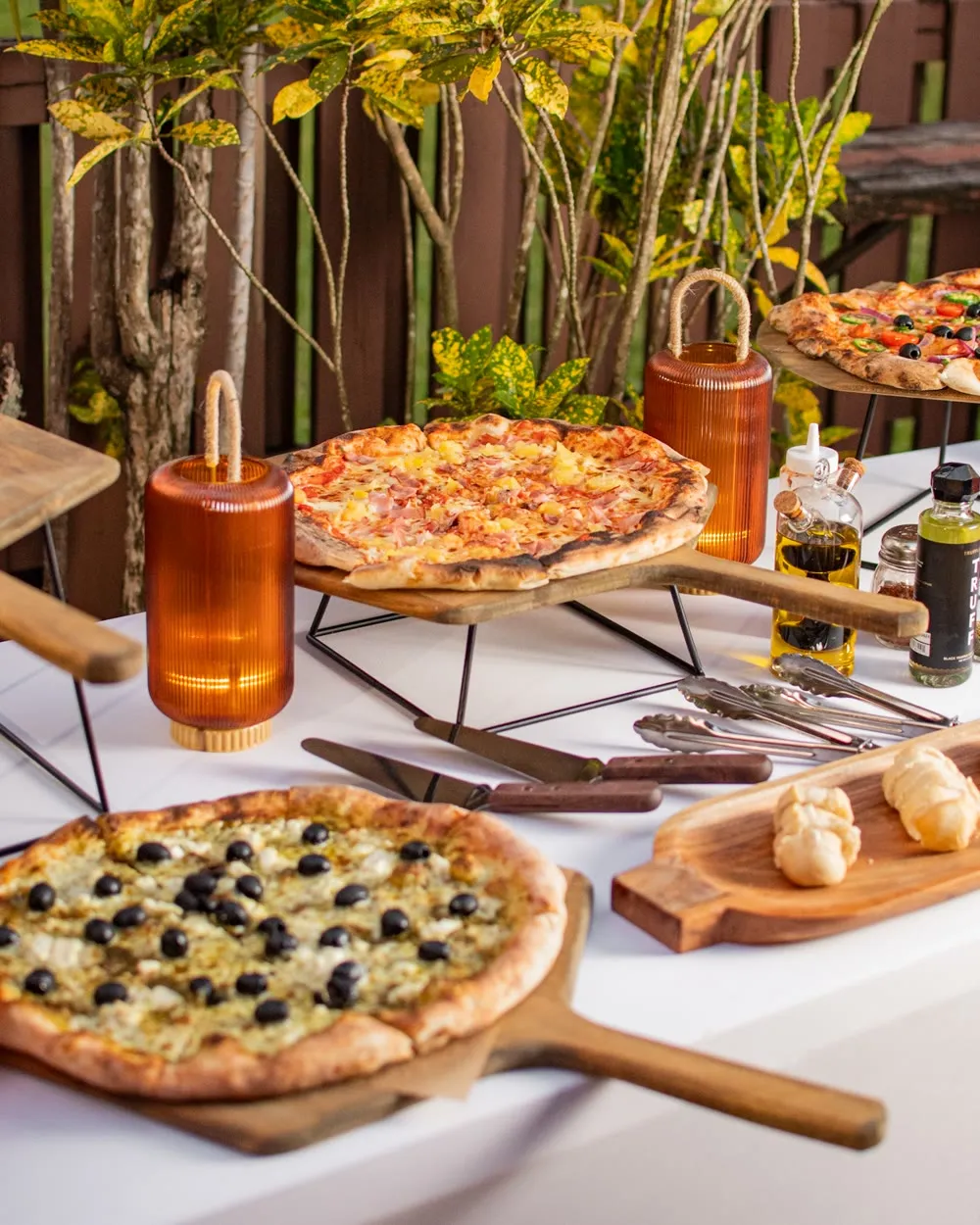 A My Way Pizza catering station set for a corporate event, with pizzas plated on wooden boards