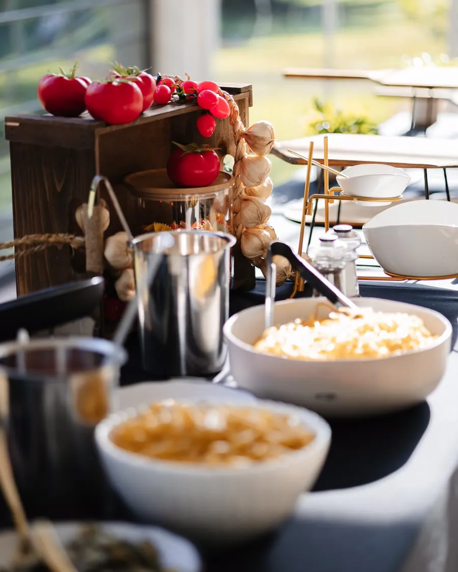 A styled catering station with heirloom tomatoes and garlic in daylight